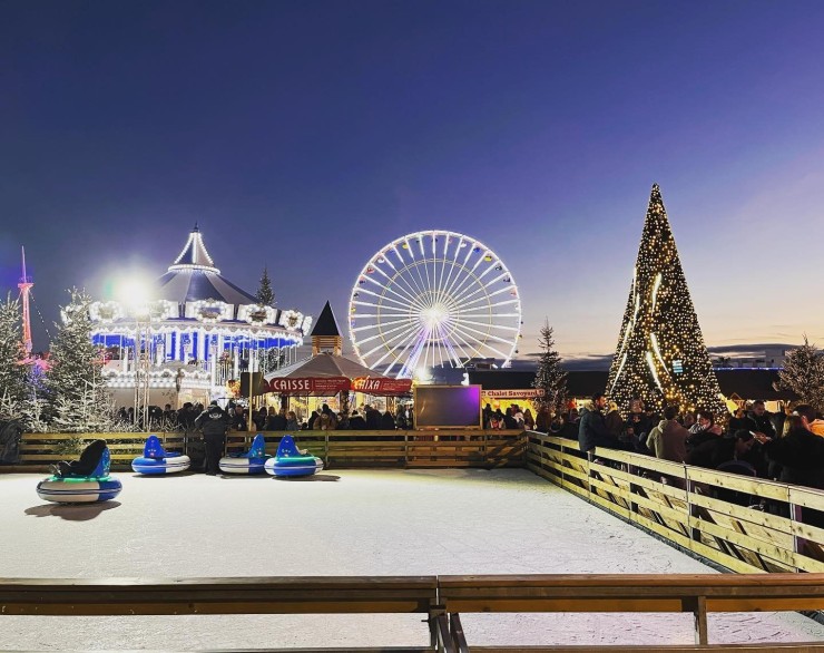 Pista de hielo con carrusel, noria y árbol de Navidad iluminado en el Village de Noël de Barcarès.